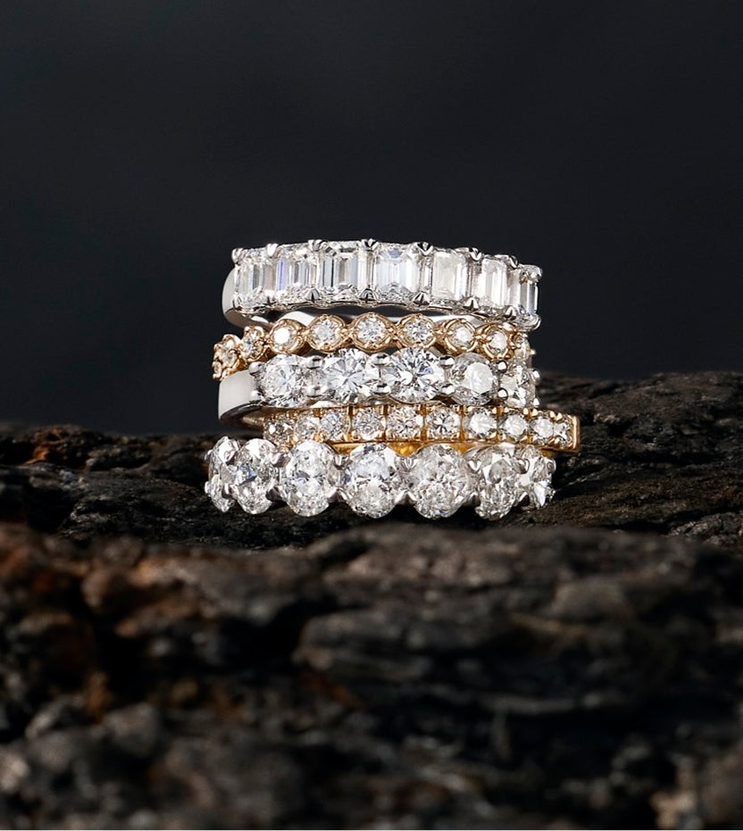 Stacked emerald, round and oval cut diamond bands in white and yellow gold