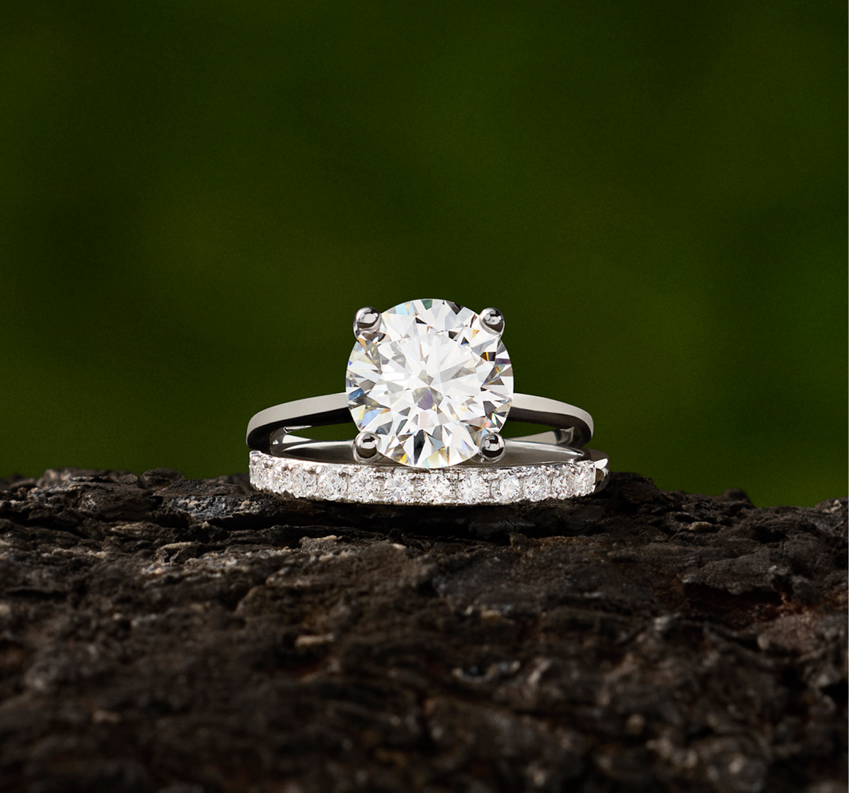 Round brilliance solitaire engagement ring stacked on a pavé wedding band, both in white gold.